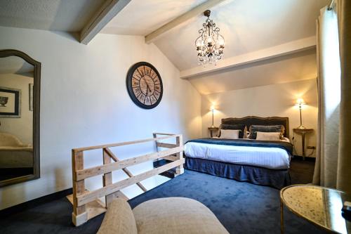 サン・レミ・ド・プロヴァンスにあるHôtel Gounodのベッドルーム1室(ベッド2台、壁掛け時計付)