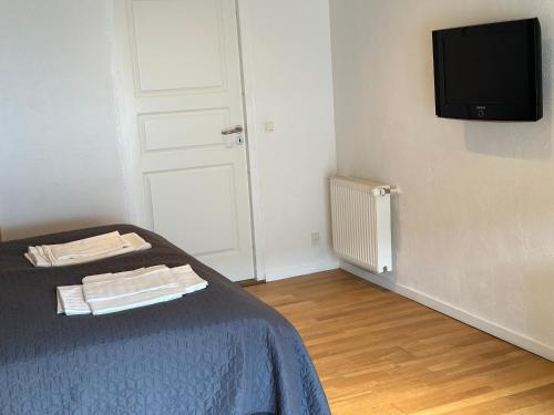 a room with a bed and a tv on a wall at Tollundgaard Golf Park & Apartments in Funder Kirkeby