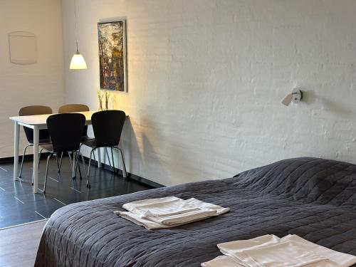 a bedroom with a bed and a table and chairs at Tollundgaard Golf Park & Apartments in Funder Kirkeby