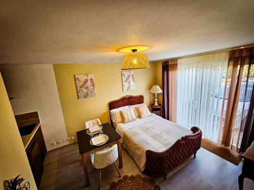 a bedroom with a bed and a table with a night stand at Appart type Hôtel, à 4 min du centre ville de Vaison-la-Romaine in Vaison-la-Romaine