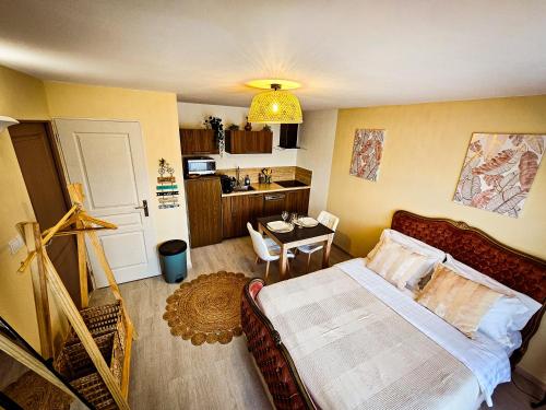 une chambre avec un lit et une table et une cuisine dans l'établissement Appart type Hôtel, à 4 min du centre ville de Vaison-la-Romaine, à Vaison-la-Romaine
