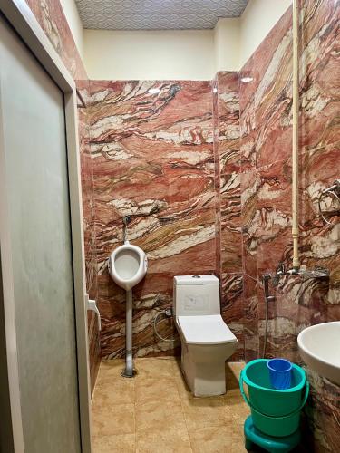 a bathroom with a urinal and a toilet and a sink at Hotel Kaka Inn in Ajmer