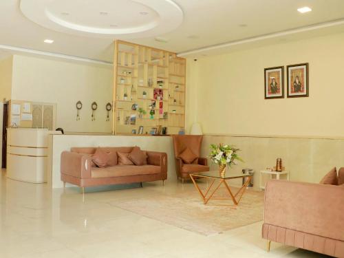 a living room with two couches and a kitchen at Sama Sohar Hotel Apartments - سما صحار للشقق الفندقية in Sohar