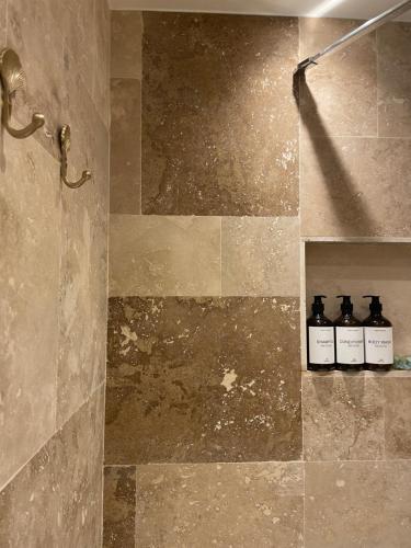 - une salle de bains avec 3 bouteilles d'huiles essentielles sur une étagère dans l'établissement M du Prado, à Marseille