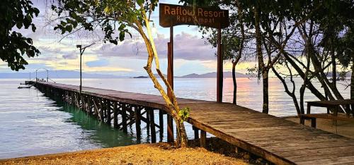 a wooden dock with a sign on the water at Raflow Resort Raja Ampat in Tapokreng