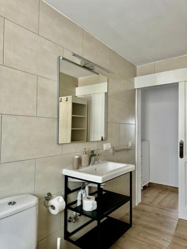 a bathroom with a sink and a mirror and a toilet at Apartamento Luna by Vulcano Homes in Nazaret
