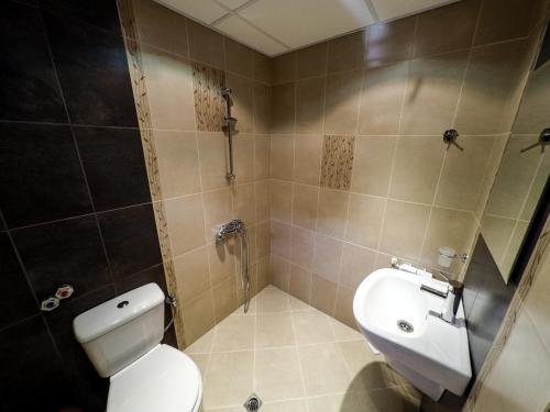 a bathroom with a toilet and a sink in it at Divna Guest House in Dospat