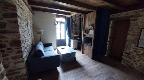 un salon avec un canapé bleu et une fenêtre dans l'établissement Gîte de l'Archerie classé 4 étoiles pour 4 personnes,, à Saint-Léger-des-Bois