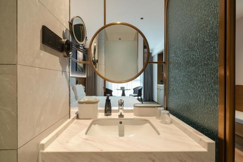 a bathroom with a sink and a mirror at Atour X Hotel Xiamen Railway Station South Plaza in Xiamen