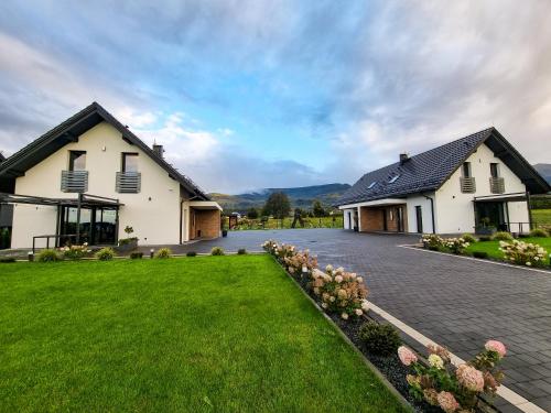 a house with a green lawn in front of it at TRZY SOSNY LOFT APARTMENTS in Ściegny