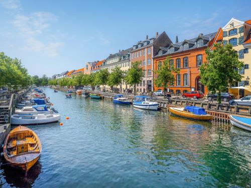 a group of boats in a river with buildings at Sanders Swan - Marvellous villa close to the center of Copenhagen in Copenhagen