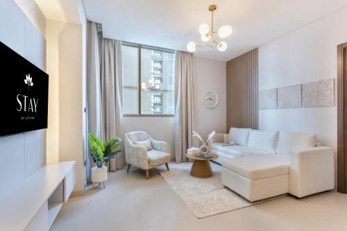 a living room with a white couch and a chair at STAY BY LATINEM Luxury 2BR Holiday Home CV A813 near Burj Khalifa in Dubai
