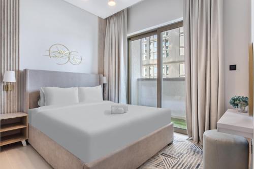 a bedroom with a large white bed and a window at STAY BY LATINEM Luxury 2BR Holiday Home CV A813 near Burj Khalifa in Dubai