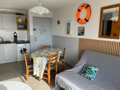 une petite cuisine avec une table et une salle à manger dans l'établissement Port Camargue P2 cabine, au Grau-du-Roi