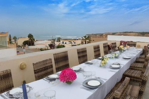a long table with plates and flowers on a balcony at Panoramic View Villa, 4 Bed, Pool in Mirleft