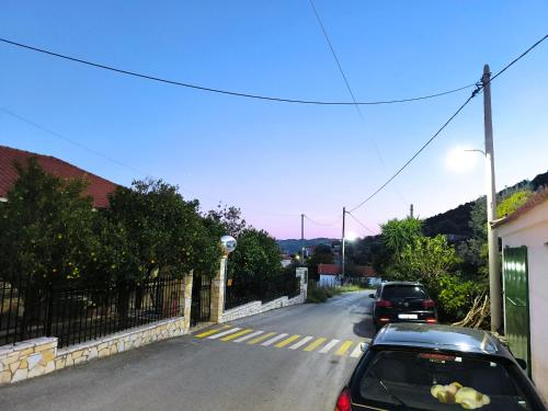 a street with two cars parked on the road at HoneyHouse in Kádhion