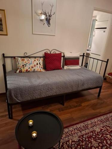 a bed with pillows and a table in a room at Tunnelmallinen retroyksiö in Rovaniemi