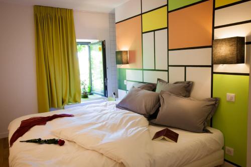 a bedroom with a large bed with a green wall at Les chambres de l'Alouette in Ponas
