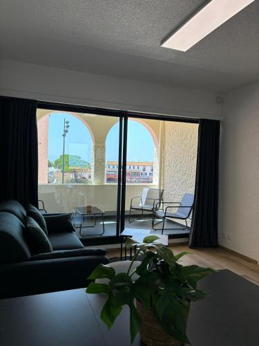 un salon avec un canapé et une grande fenêtre dans l'établissement Appartement Le Barcarès, à Dosse Petit