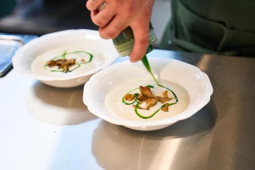 a person is pouring food into a bowl of food at Naantali Spa Hotel in Naantali
