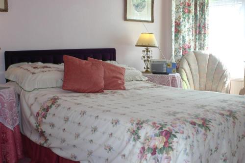 a bedroom with a bed with a floral comforter at Knightsrest in Burnham on Sea