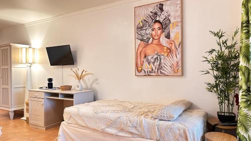 a bedroom with a bed and a painting on the wall at Grenade 21 vue mer proche plage dans Complexe type Village Vacances in Sainte-Luce