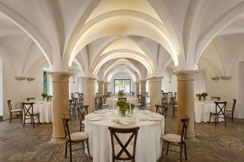 a banquet hall with white tables and chairs at Penha Longa Resort in Sintra