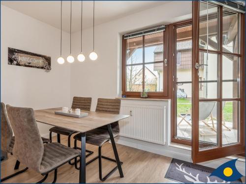 a dining room with a table and chairs and a window at Ferienwohnung Hornig in Garz-Usedom