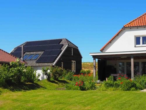 a house with solar panels on the roof at Ruime boerderij met haard, pooltafel en veranda in Goilberdingen