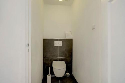 a bathroom with a white toilet in a room at Ruime boerderij met haard, pooltafel en veranda in Goilberdingen