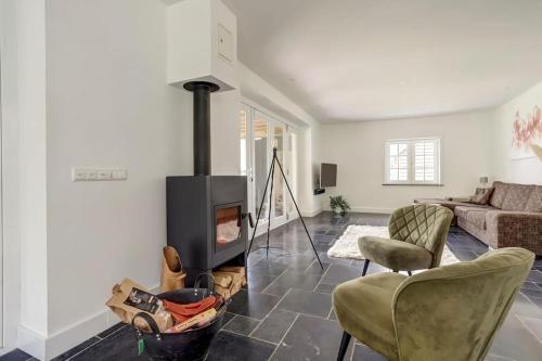 a living room with a fireplace and a couch at Ruime boerderij met haard, pooltafel en veranda in Goilberdingen