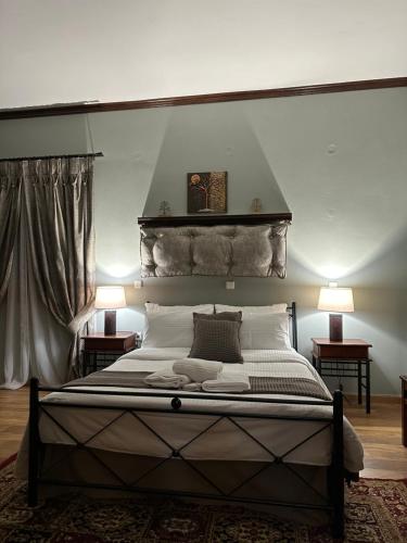 a bedroom with a large bed with two lamps at George Room 2 in Arachova