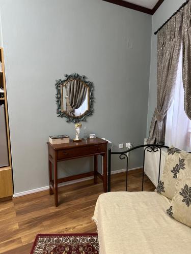 a bedroom with a mirror and a table with a bed at George Room 2 in Arachova