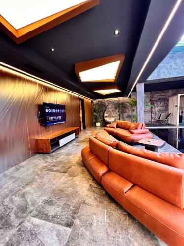 a lobby with leather couches and a flat screen tv at Motel Villa Princi in Kosovo Polje