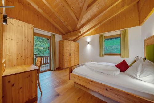 a bedroom with a bed in a wooden house at Thalerhof Appartement Verena in Verano