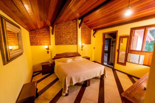a bedroom with a bed in a room with yellow walls at Pousada Imperial Koeler in Petrópolis