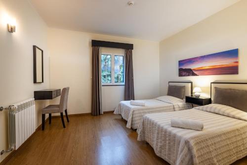 a hotel room with two beds and a window at A Casa do Lagar in São Jorge