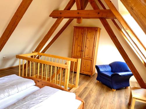 Camera mansardata con letto e sedia blu di Ferienanlage Freyenhöfe a Baiersbronn