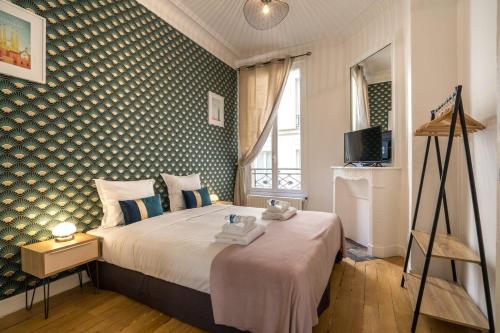 une chambre avec un lit et un mur dans l'établissement Apartment 3BR - 10P - Passy - Eiffel Tower, à Paris