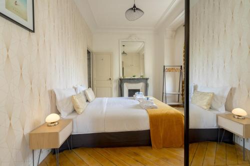 une chambre avec un grand lit blanc et un miroir dans l'établissement Apartment 3BR - 10P - Passy - Eiffel Tower, à Paris