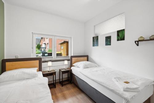 two beds in a room with a window at Sali-Homes Monteur Stay in Kleve