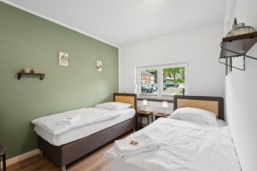 two beds in a room with a window at Sali-Homes Monteur Stay in Kleve