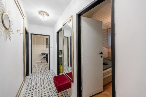 a hallway leading to a bedroom with a red chair at Luxusný apartmán pri nemocnici in Košice