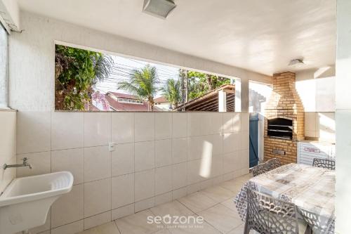 ein Badezimmer mit Waschbecken und Fenster in der Unterkunft Casa Espaçosa 300m da Praia do Peró - VVP0027 in Peró