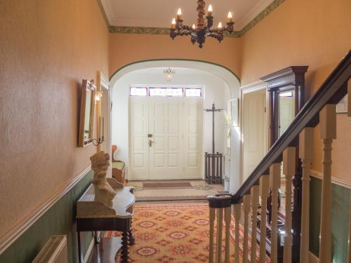 a hallway with a white door with a chandelier at Kill House, Kingstown in Clifden