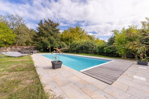- une piscine dans une cour avec une terrasse en bois dans l'établissement Appartement cosy tout équipé, à Pissos