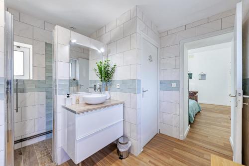 a white bathroom with a sink and a shower at Appartement cosy tout équipé in Pissos