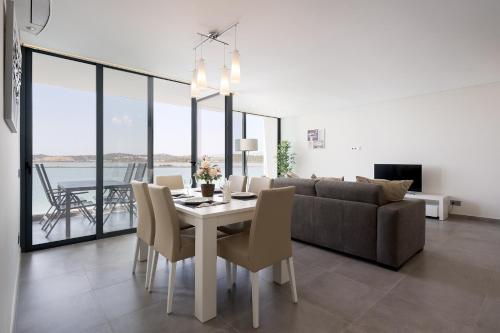a dining room and living room with a table and chairs at Portimão Ocean Breeze With Pool by Homing in Lagoa