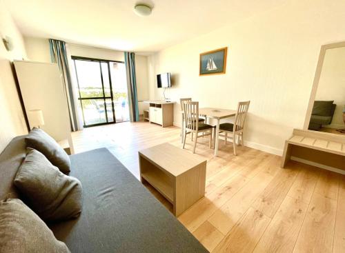 a living room with a couch and a table at Caporizon-l'Archipel-T1-Piscine-centre ville-Terrasse in La Rochelle