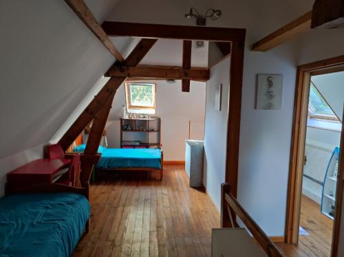 Cette chambre mansardée comprend un lit et une fenêtre. dans l'établissement Le Domaine De CLABAUT, à Écurie